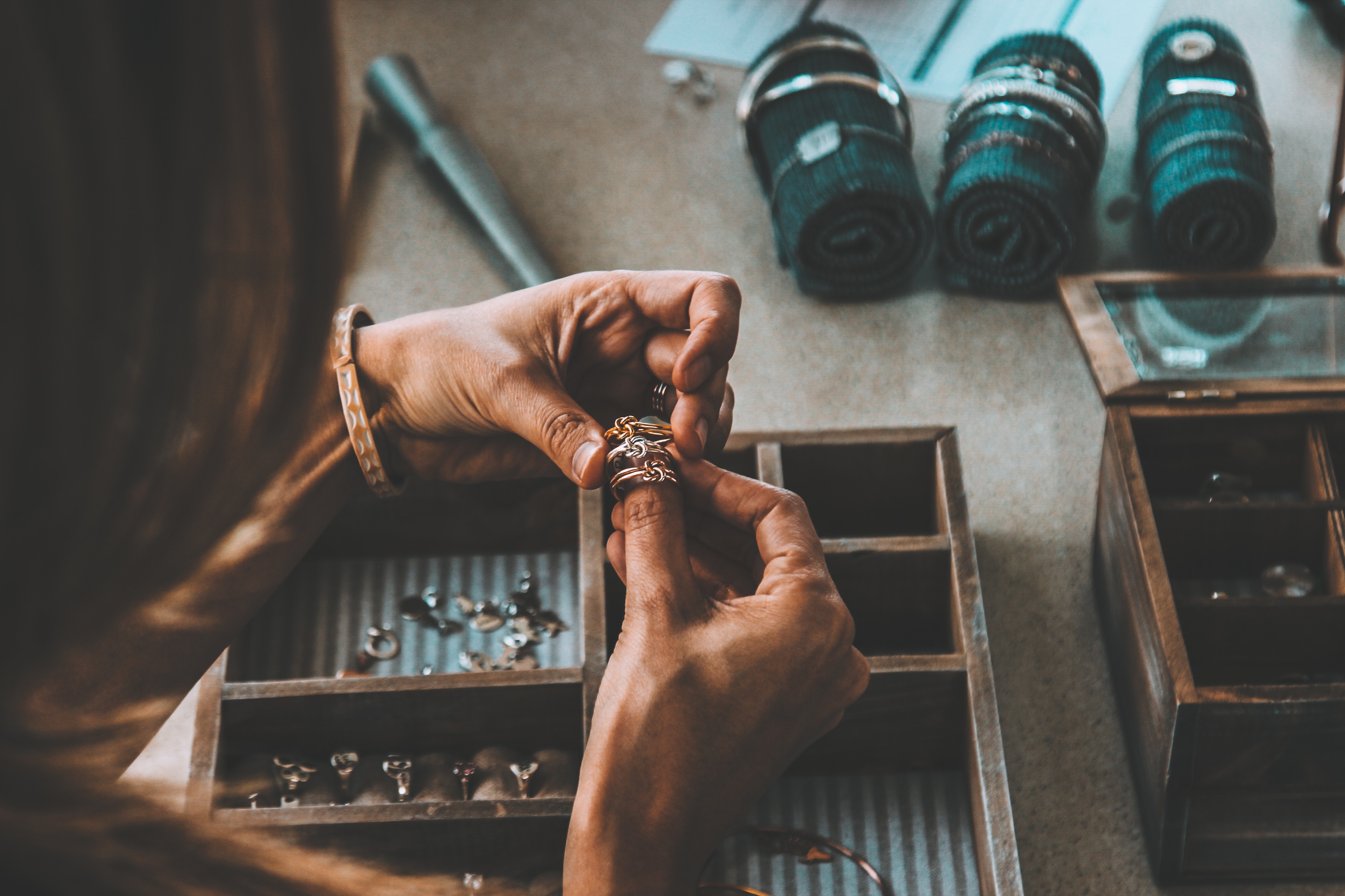 a pair of hands gently comparing three rings made from different metals