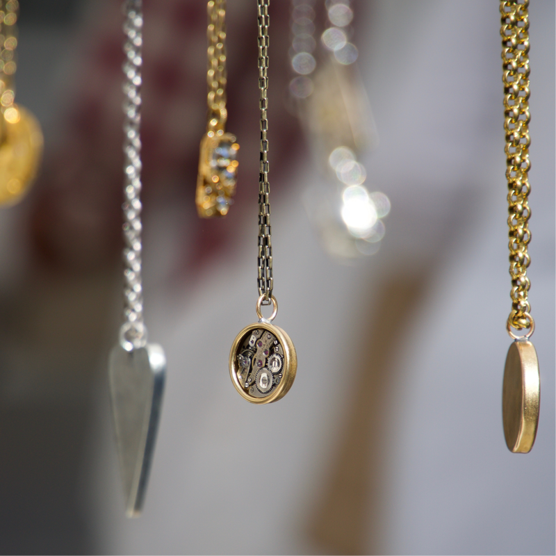 several bespoke necklaces hanging on display