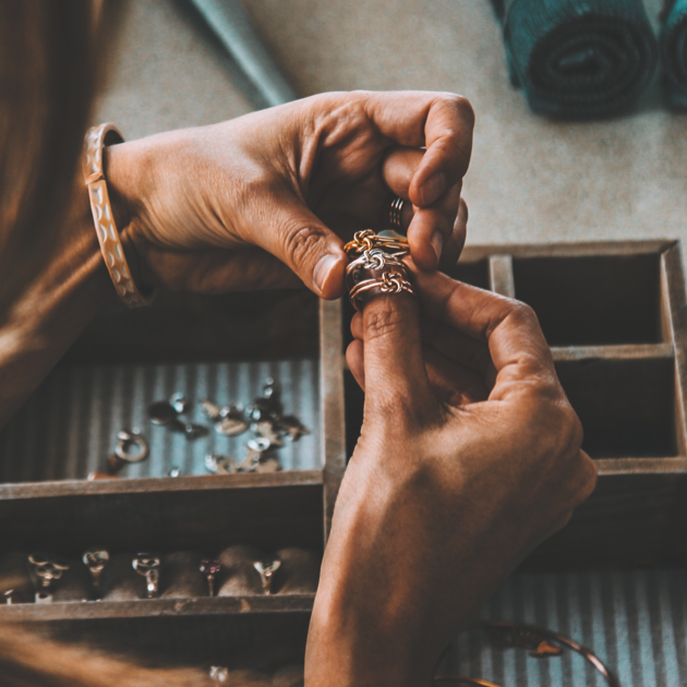 a pair of hands gently comparing three rings made from different metals